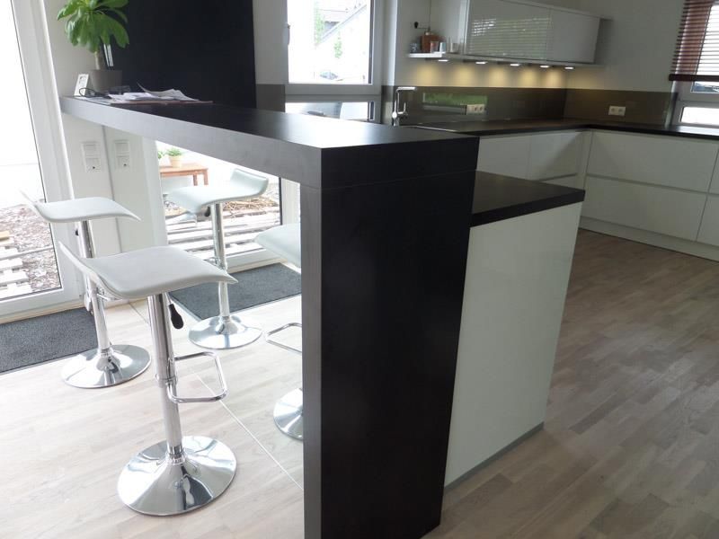 Eine Küche mit schwarzer Arbeitsplatte und weißen Schränken