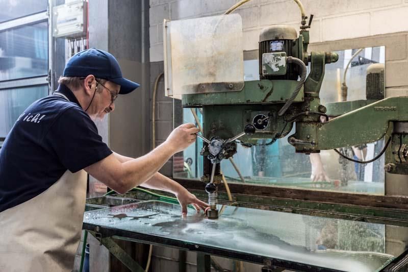Ein Mann arbeitet in einer Fabrik an einer Maschine.