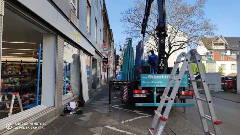 Vor einem Gebäude parkt ein LKW mit einem daran befestigten Kran.