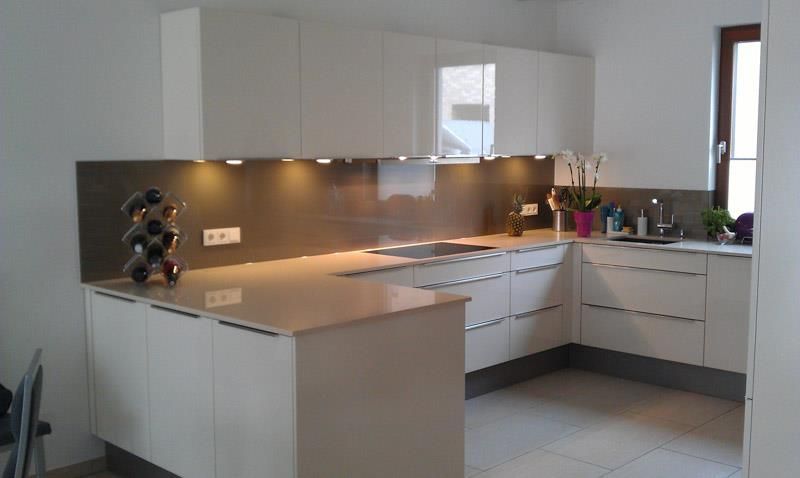 Eine Küche mit weißen Schränken und einem Weinregal auf der Theke.