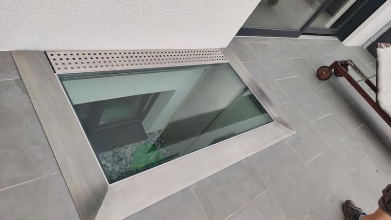 Eine Person steht vor einem Fenster auf dem Boden.