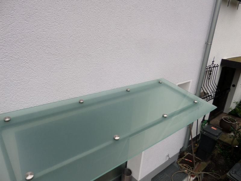 An der Seite eines Gebäudes ist ein Glasdach angebracht.