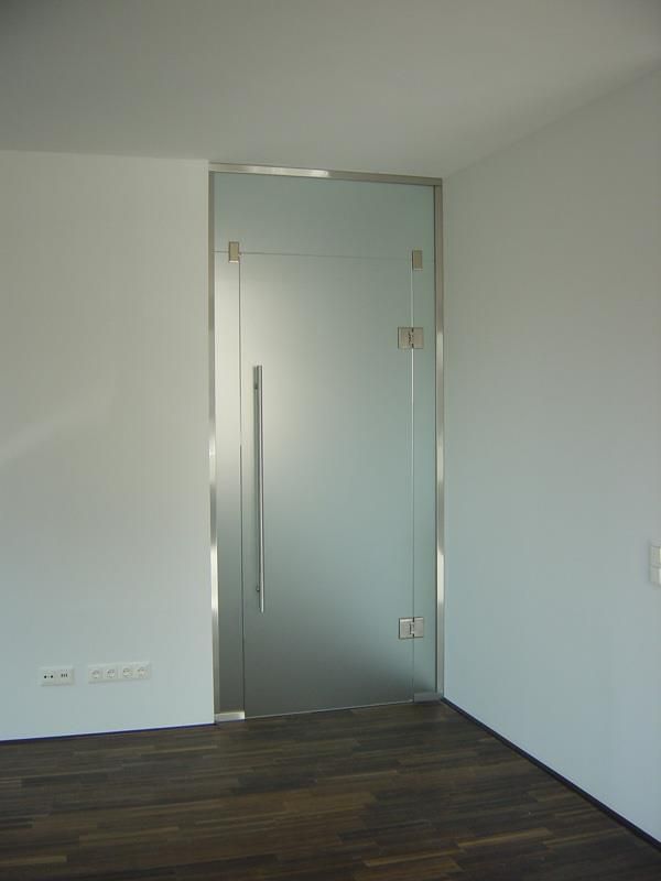 Ein leerer Raum mit einer Glastür und einem Holzboden