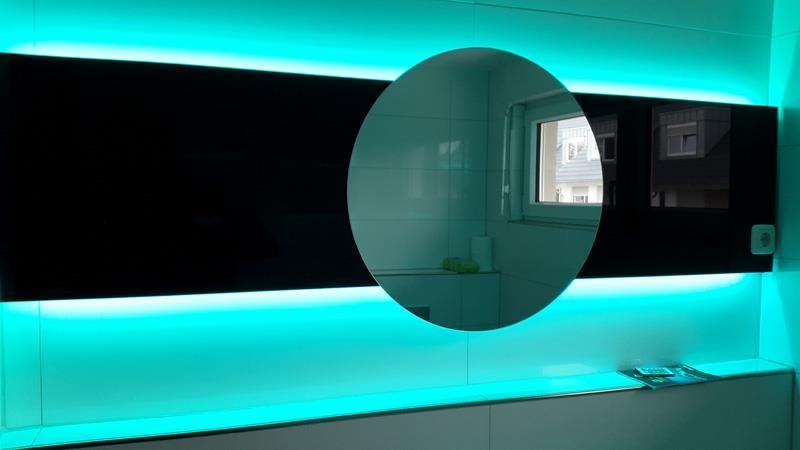 Ein Badezimmer mit einem Spiegel und blauen Lichtern an der Wand.