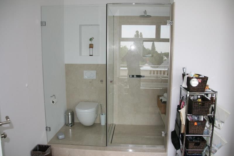 Ein Badezimmer mit Toilette und ebenerdiger Dusche