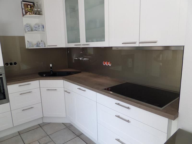 Eine Küche mit weißen Schränken und einem Herd mit Backofen