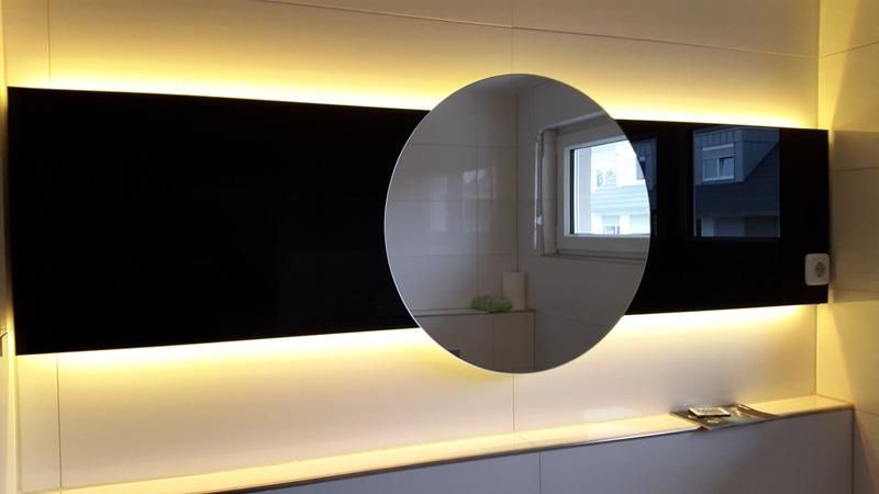 Ein Badezimmer mit großem Spiegel und Fenster.