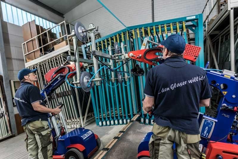 Zwei Männer arbeiten in einer Fabrik an einer Maschine.