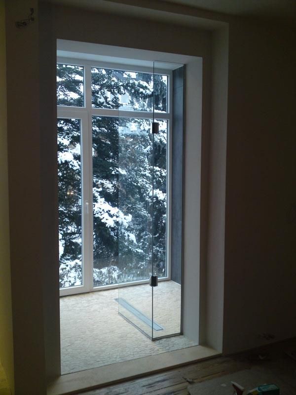 Ein Raum mit einem großen Fenster und einer Glasschiebetür