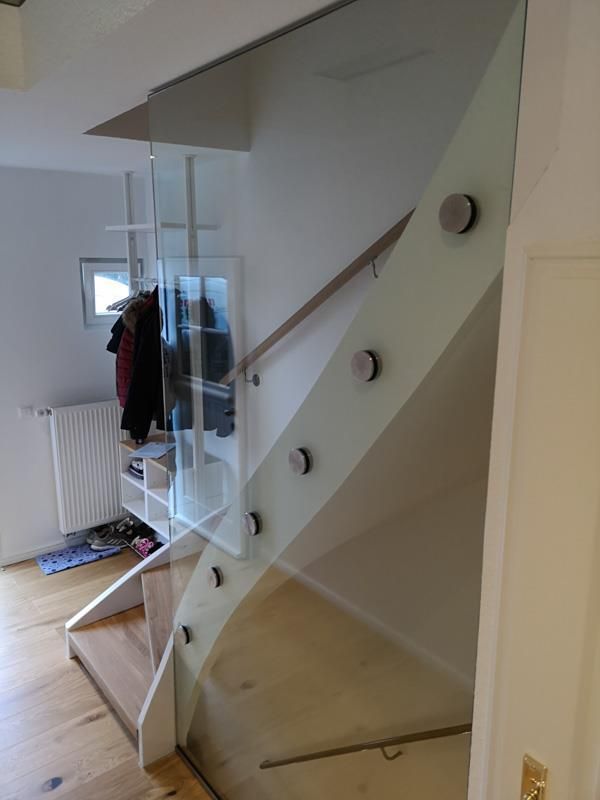 Eine Treppe mit Glasgeländer und Holzstufen