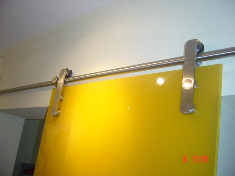 Eine gelbe Glasschiebetür mit einem Edelstahlgeländer