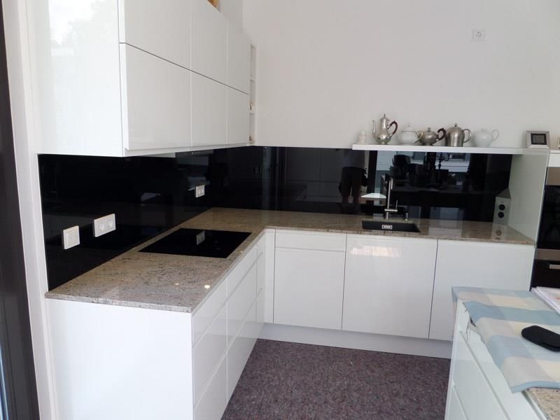 Eine Küche mit weißen Schränken und Granit-Arbeitsplatten