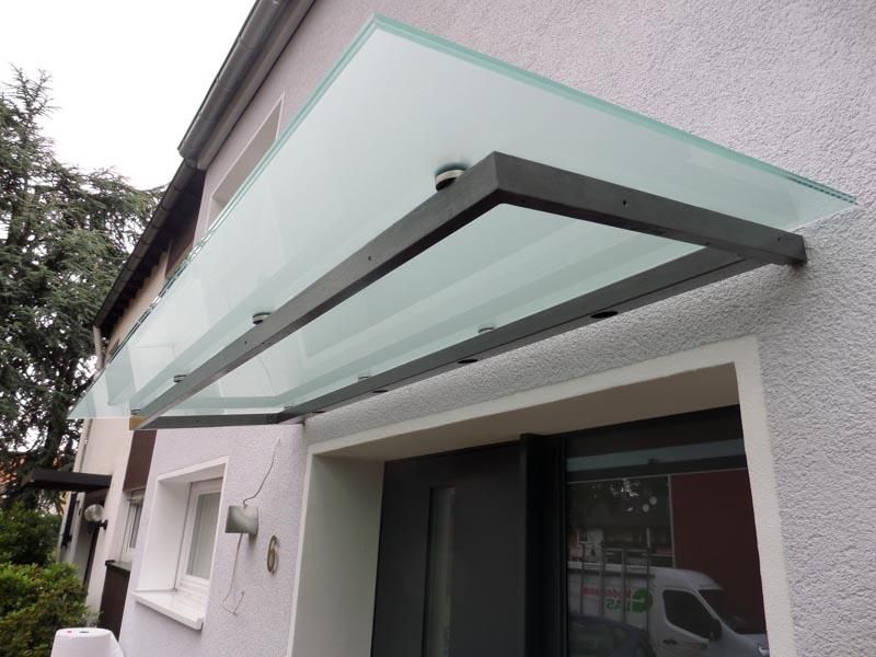 Ein weißes Haus mit einem Glasdach über der Tür