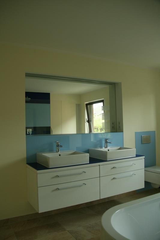 Ein Badezimmer mit zwei Waschbecken und einem großen Spiegel