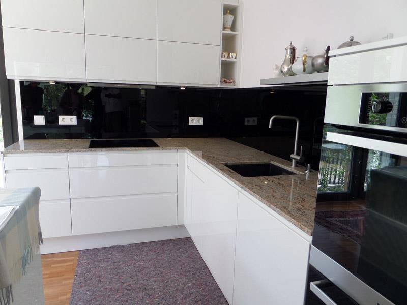 Eine Küche mit weißen Schränken und Granit-Arbeitsplatten