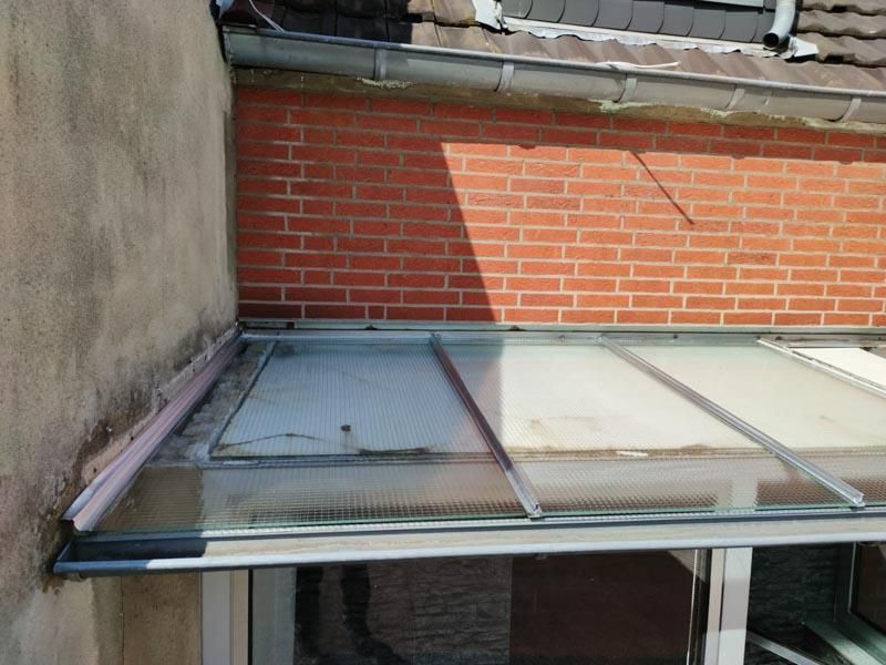 An einem Backsteingebäude ist ein Glasdach angebracht.