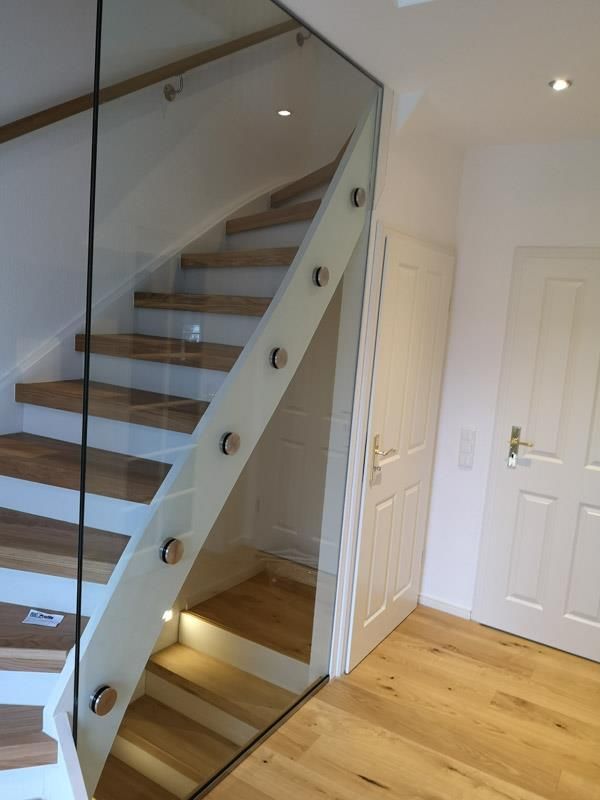 Eine Treppe mit Glasgeländer und Holzstufen