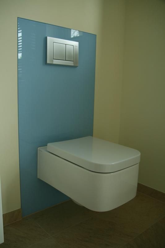 Eine weiße Toilette ist in einem Badezimmer an der Wand montiert