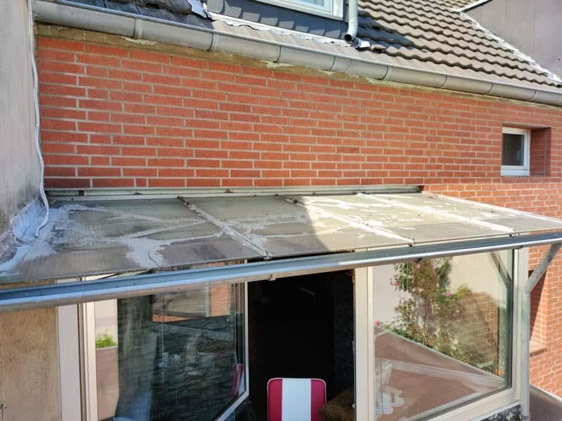 Ein Backsteingebäude mit einem Fenster und einem Vordach darüber.