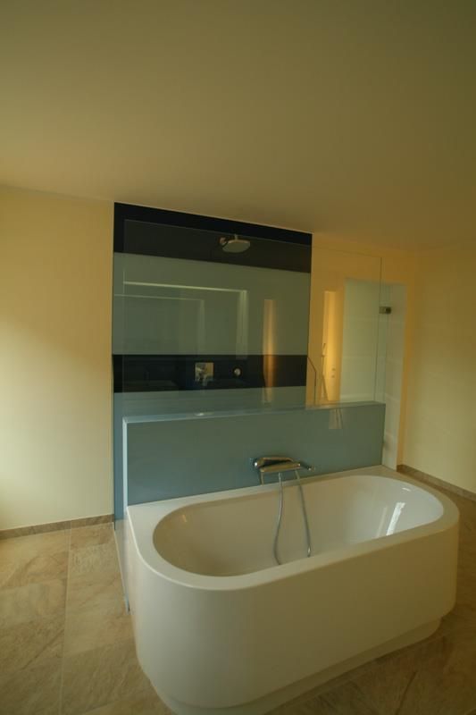 Eine Badewanne in einem Badezimmer mit einer blauen Wand dahinter