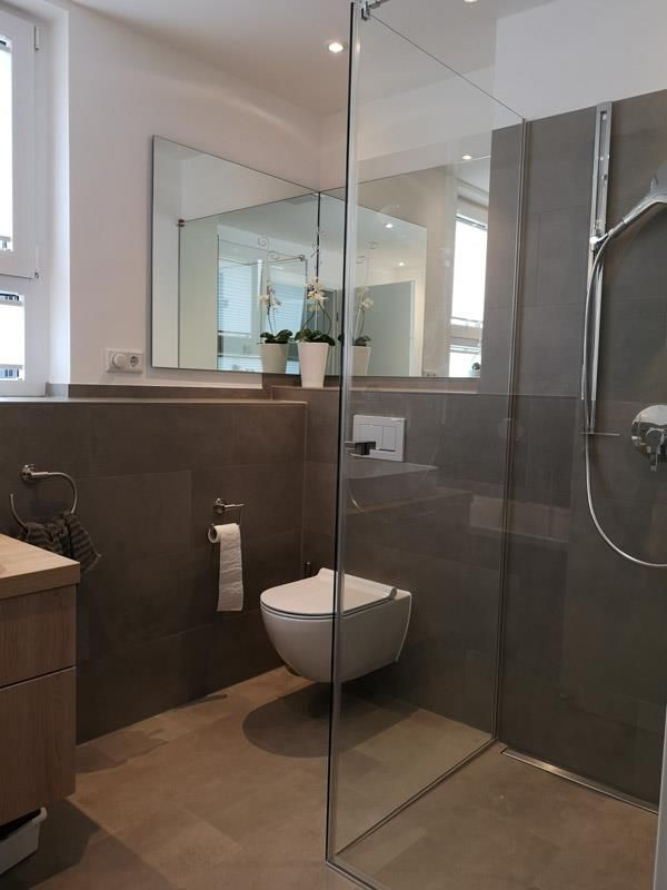 Ein Badezimmer mit Toilette und ebenerdiger Dusche