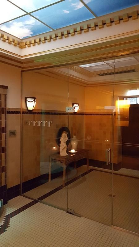 Ein Raum mit einer Glastür und einer Frauenstatue auf einem Tisch.