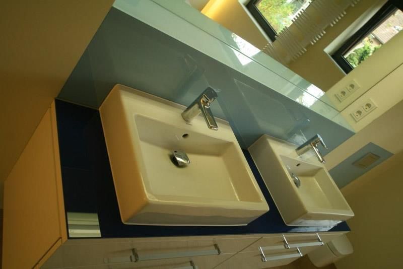 Ein Badezimmer mit zwei Waschbecken und einem Spiegel