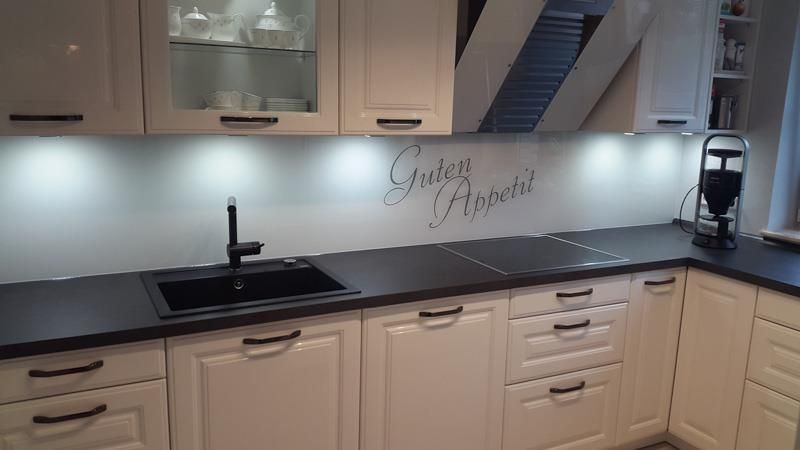 Eine Küche mit weißen Schränken und einer schwarzen Spüle.