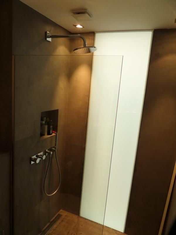 Ein Badezimmer mit ebenerdiger Dusche und Duschkopf.