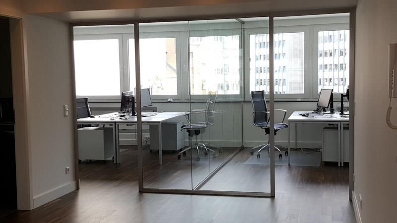 Ein Raum mit vielen Fenstern und Tischen und Stühlen