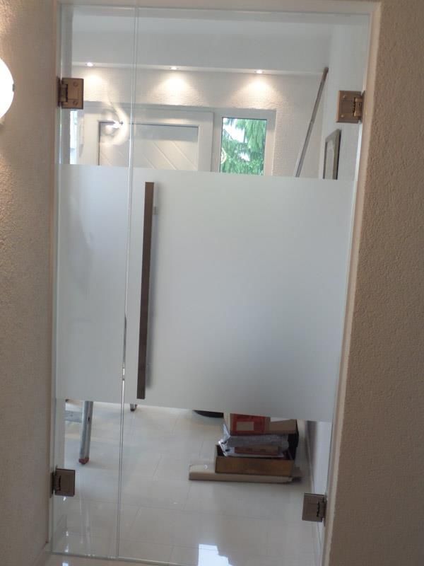 Ein Raum mit einer Glastür und einer weißen Wand