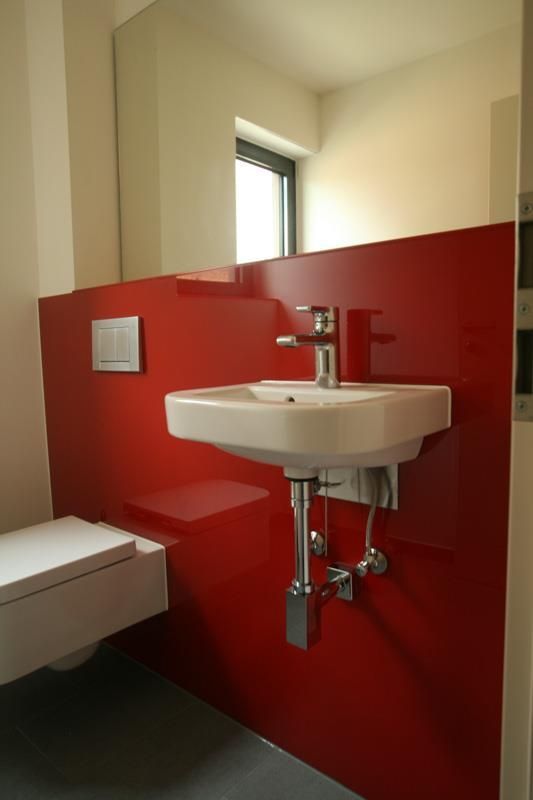 Ein Badezimmer mit einer roten Wand und einem Waschbecken