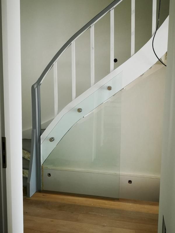 Eine weiße Wendeltreppe mit Glasgeländer