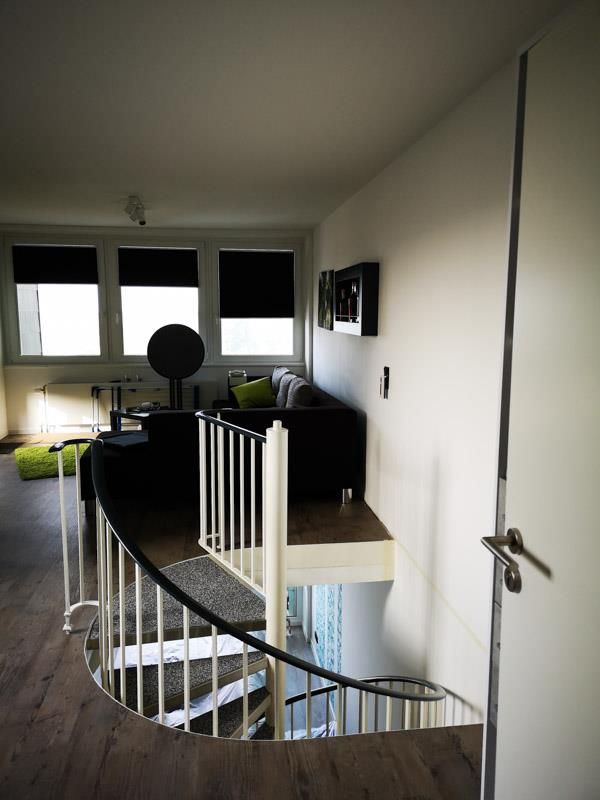 Ein Wohnzimmer mit einer Wendeltreppe in den zweiten Stock