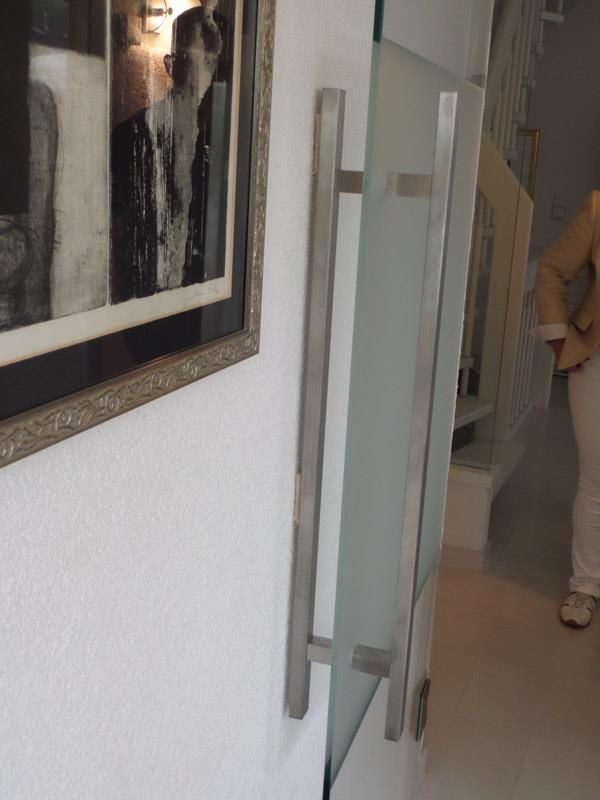 An einer Wand neben einer Glastür hängt ein Bild eines Hundes.