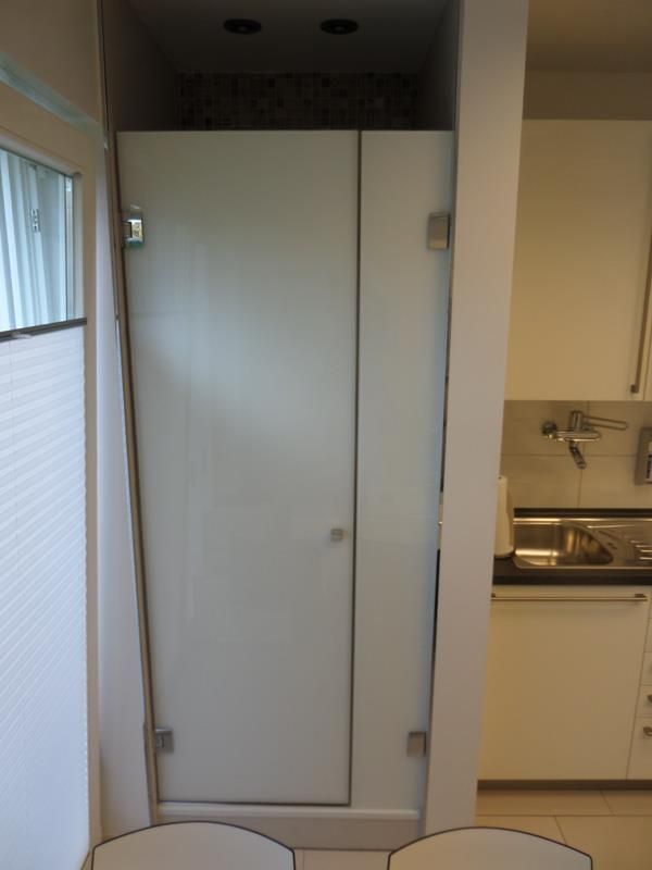 Ein weißer Schrank in einer Küche neben einem Fenster