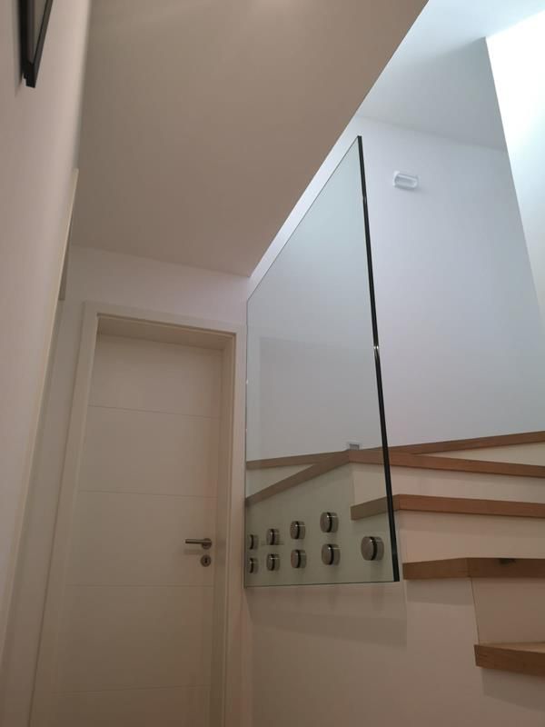 Eine Treppe mit Glasgeländer und Tür