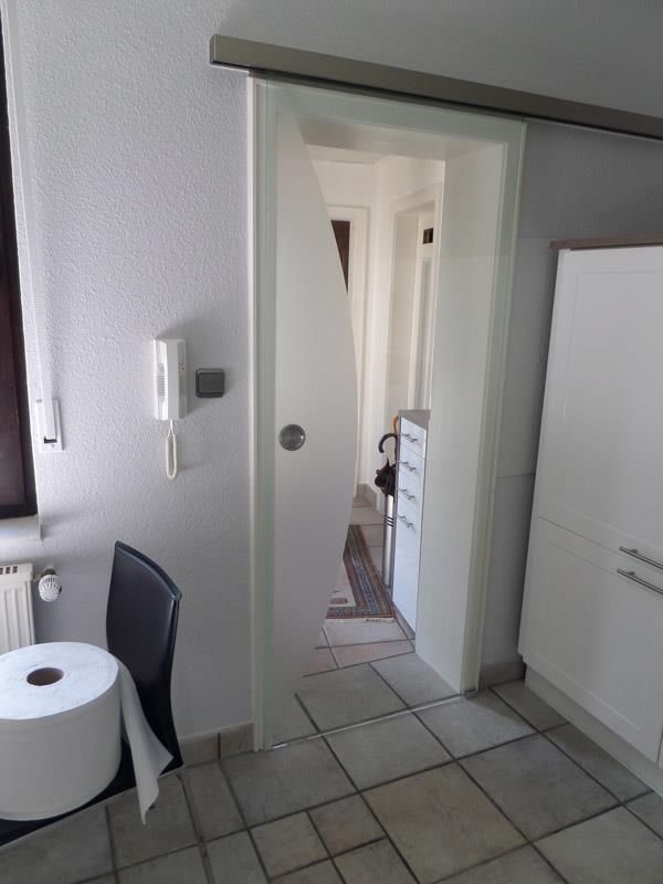 Ein Badezimmer mit einer Glasschiebetür und einer Rolle Toilettenpapier