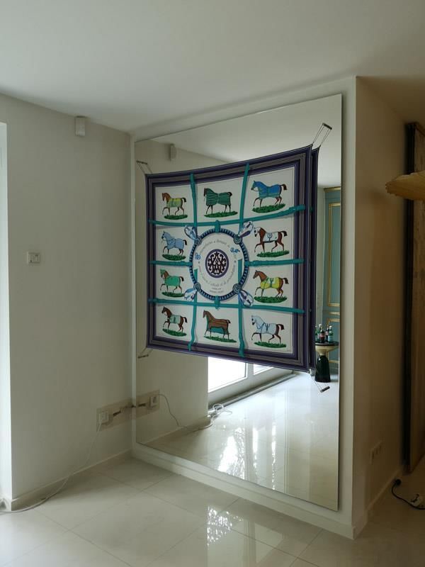 Ein großer Spiegel mit einem Bild von Pferden darauf