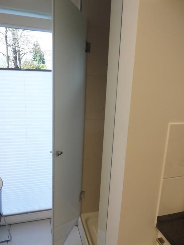 Ein Badezimmer mit einer weißen Tür und einem Fenster