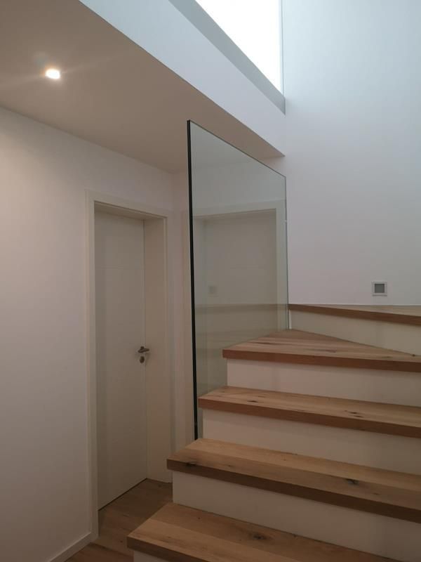 Eine Treppe mit Holzstufen und einem Glasgeländer