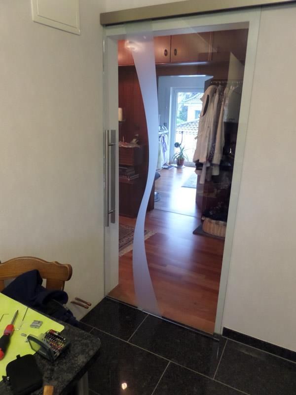 Eine Glasschiebetür öffnet sich zu einem Wohnzimmer