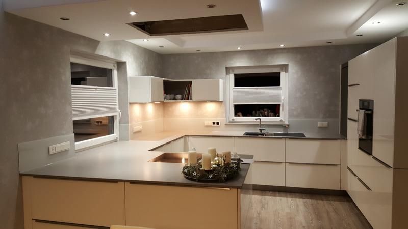 Eine Küche mit weißen Schränken und einer schwarzen Arbeitsplatte.