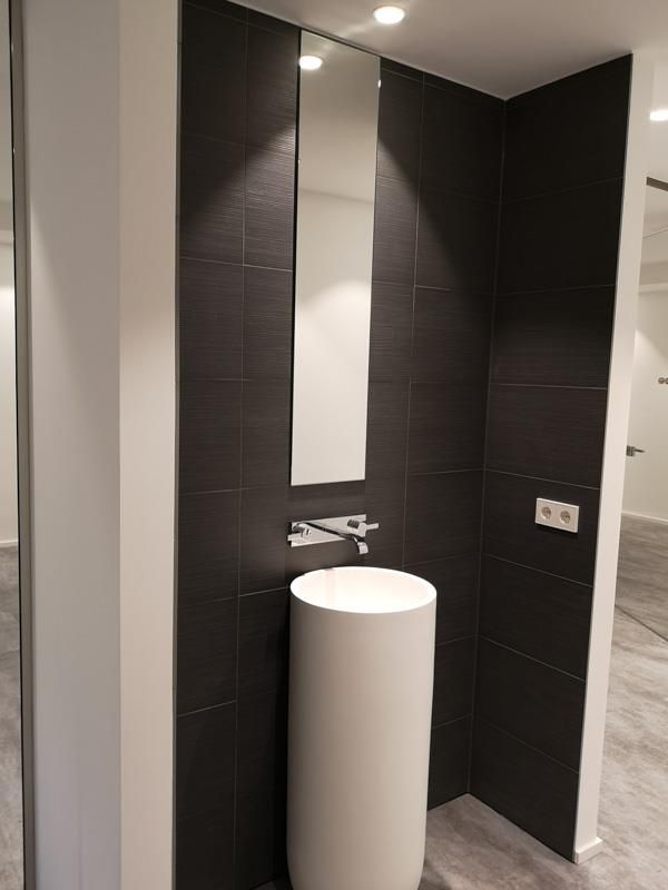 Ein Badezimmer mit Waschbecken und Spiegel an der Wand