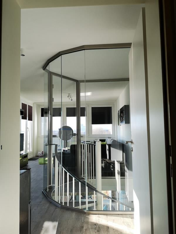 Ein Flur mit Glaswand und Treppe zum zweiten Stock