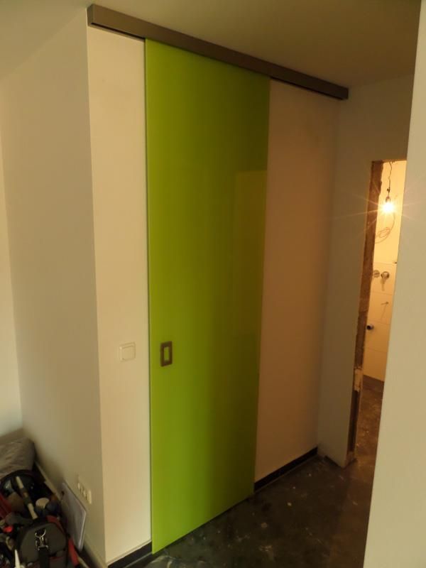 Eine grüne Schiebetür in einem Raum mit weißen Wänden