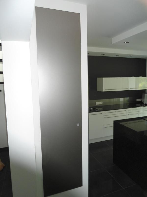 Eine Küche mit weißen Schränken und einer schwarzen Insel