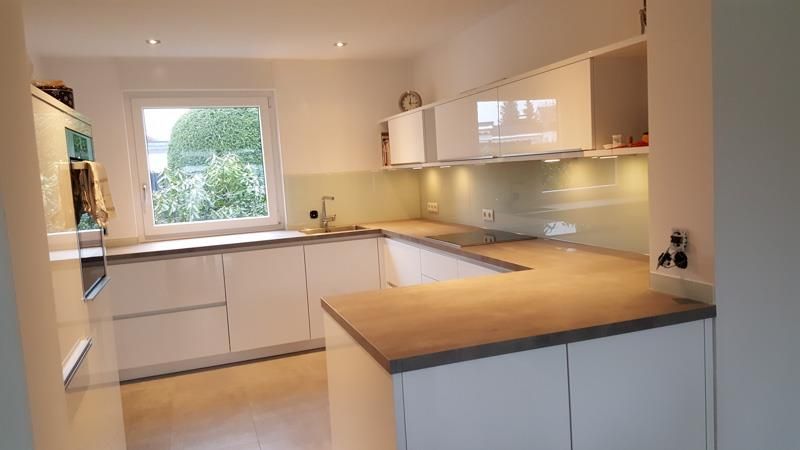 Eine Küche mit weißen Schränken und einer Holzarbeitsplatte.