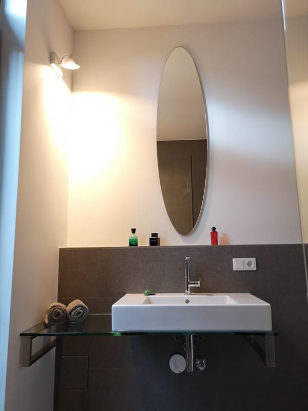 Ein Badezimmer mit Waschbecken und Spiegel an der Wand