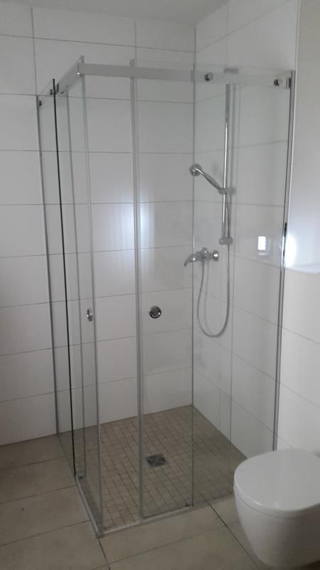 Ein Badezimmer mit Duschkabine und Toilette.